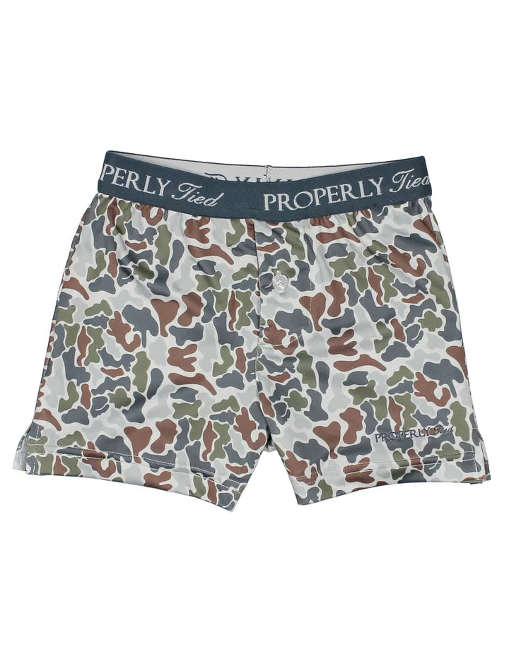 A pair of boxer briefs by Properly Tied, featuring a multi-colored camouflage pattern in green, brown, gray, and white, with a dark navy waistband displaying the brand name.